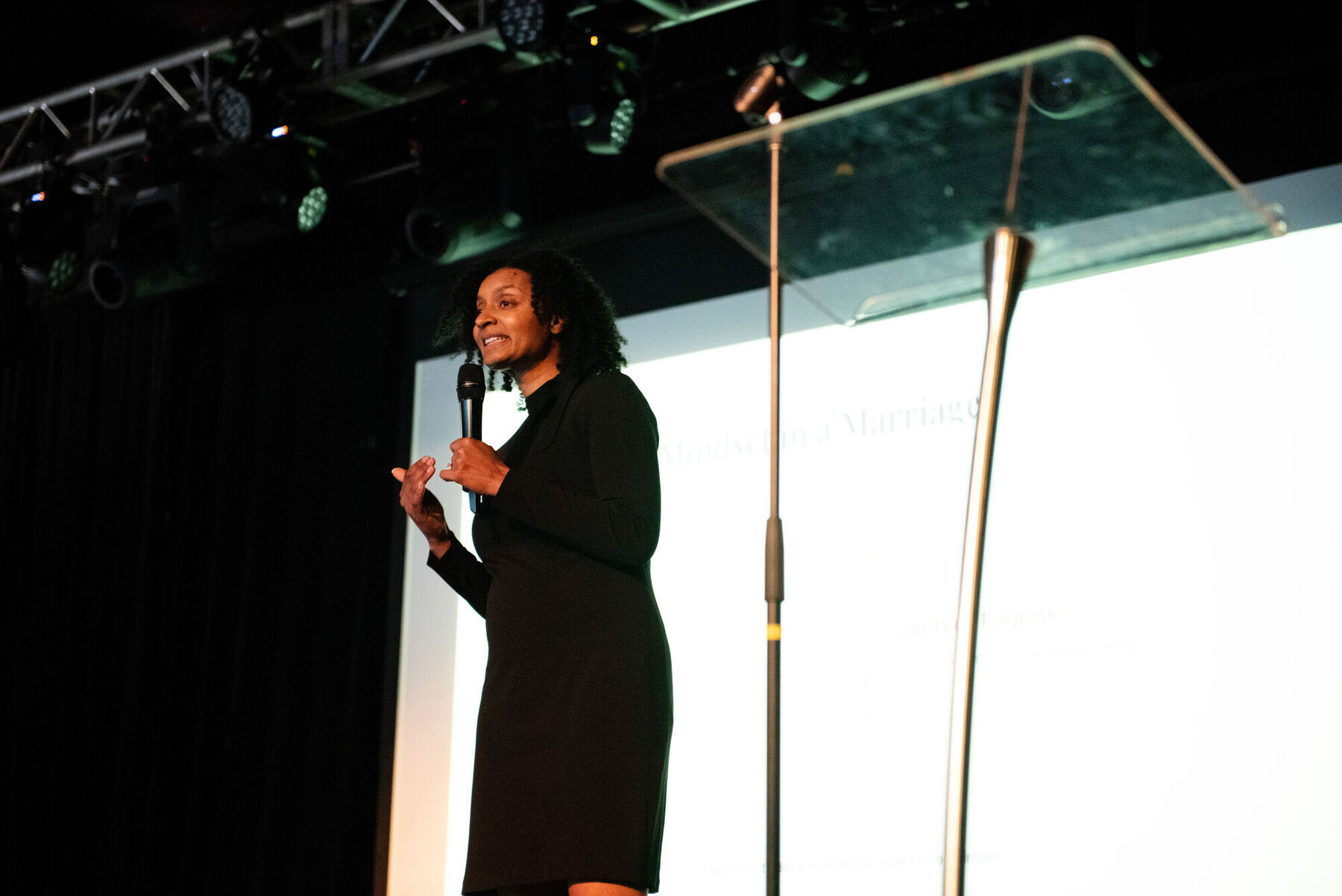 Winnifred Anderson speaking on stage with a microphone